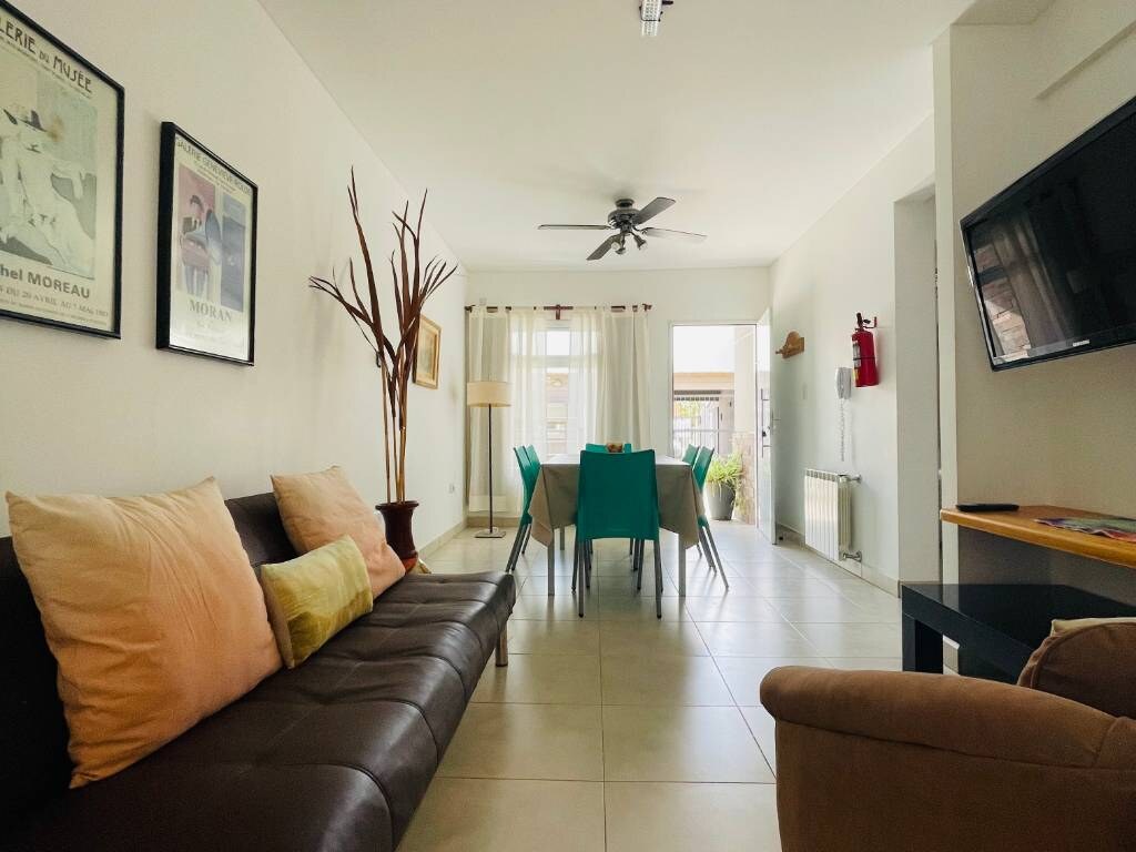 Living room with leather sofa, cushions and table with turquoise chairs