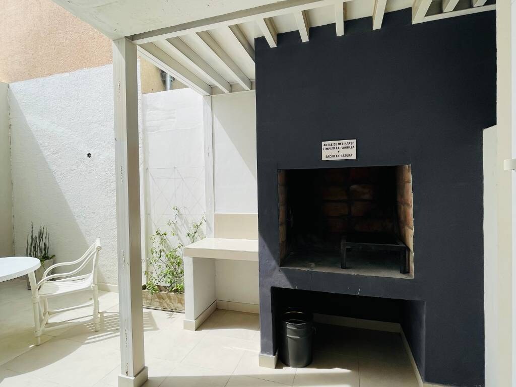 Brick barbecue grill under a pergola on the patio