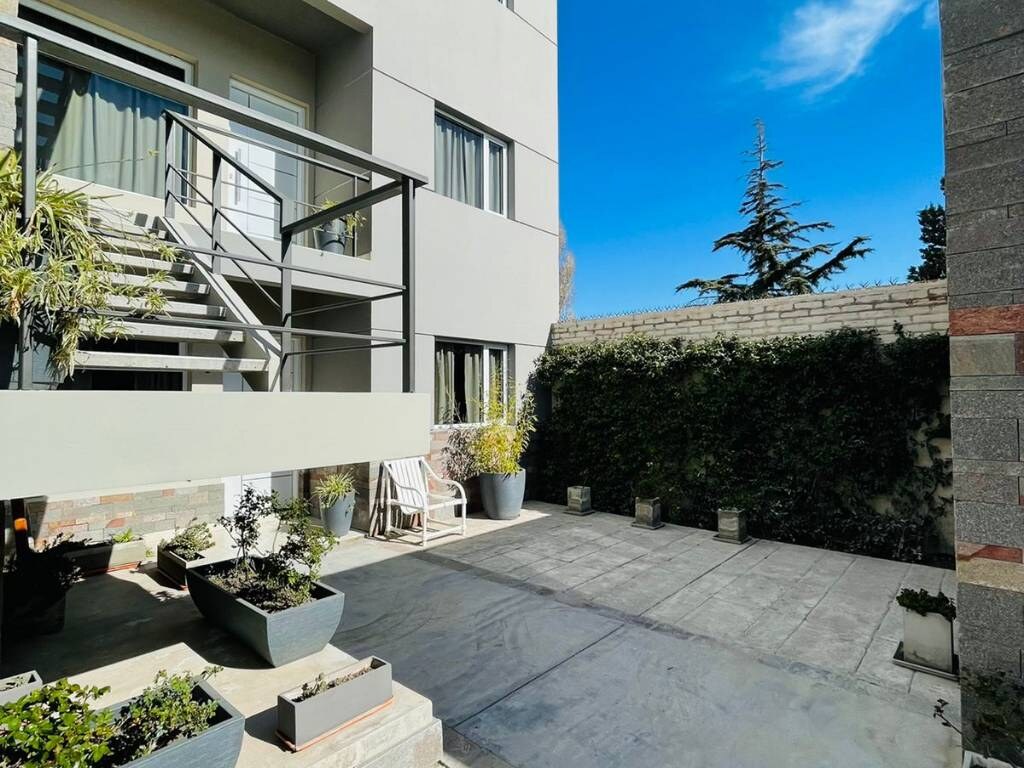 Entrance patio with planters and green hedge